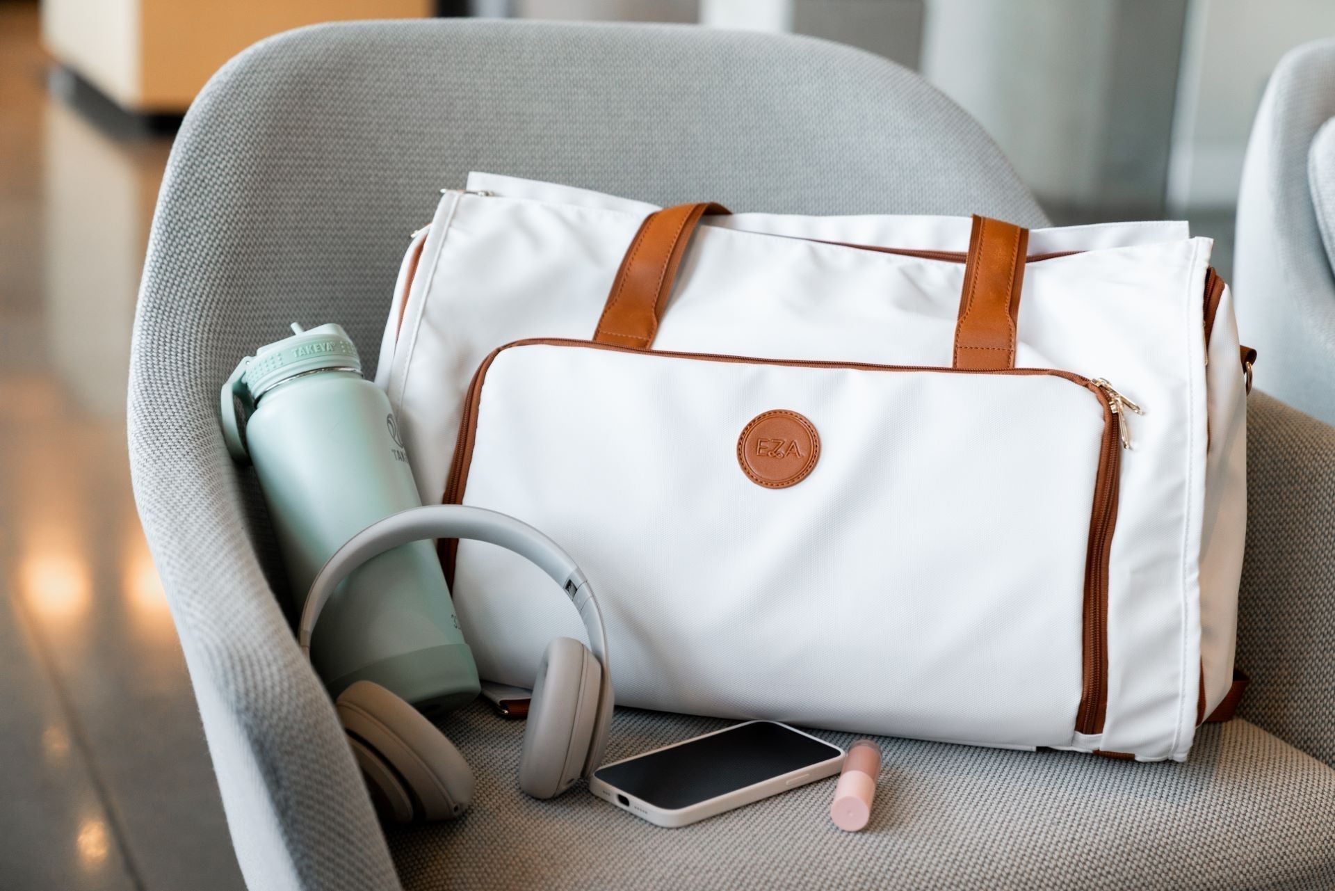 High-quality Caribbean convertible duffle bag with headphones, phone, and water bottle for versatile travel.